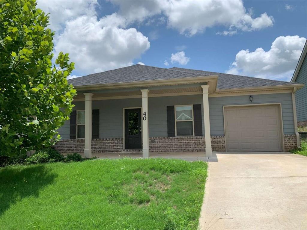 a front view of a house with a garden and yard