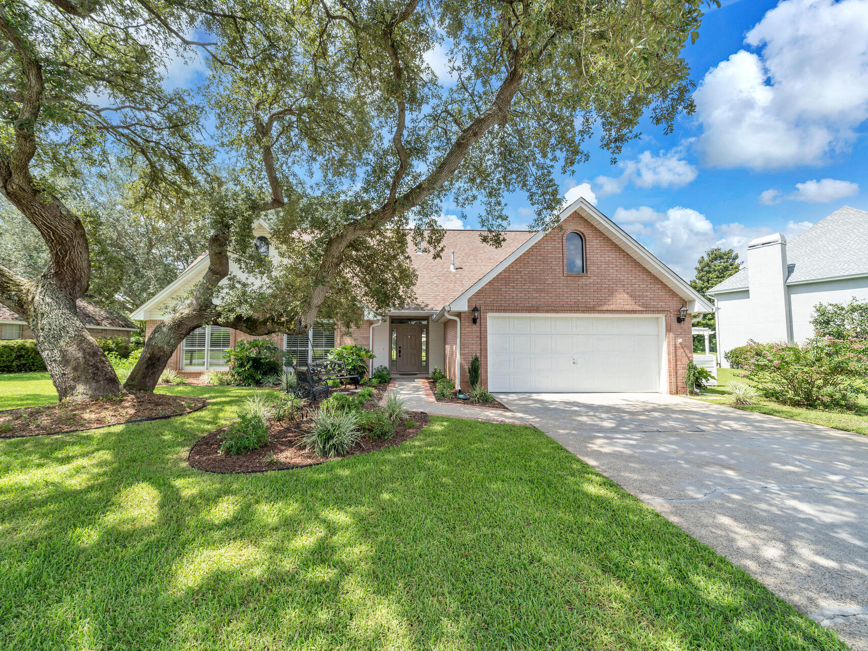 a front view of a house with a yard and trees