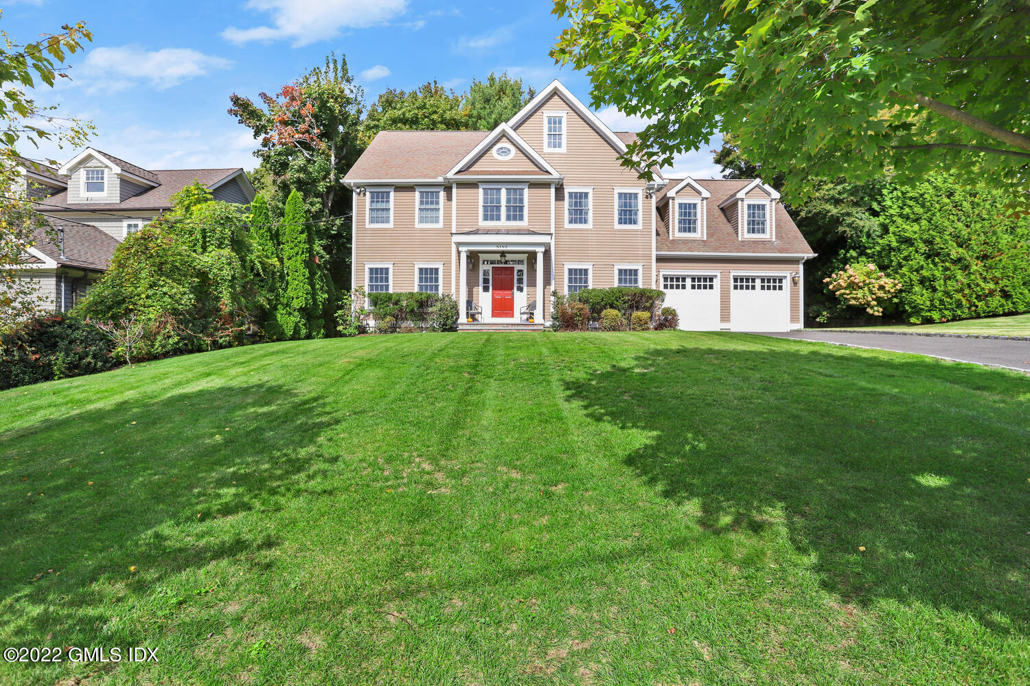 a front view of a house with yard and green space