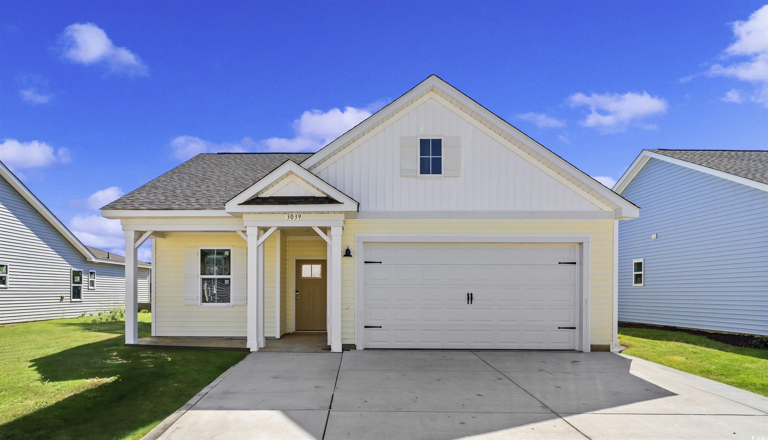 View of front facade with a garage and a front law