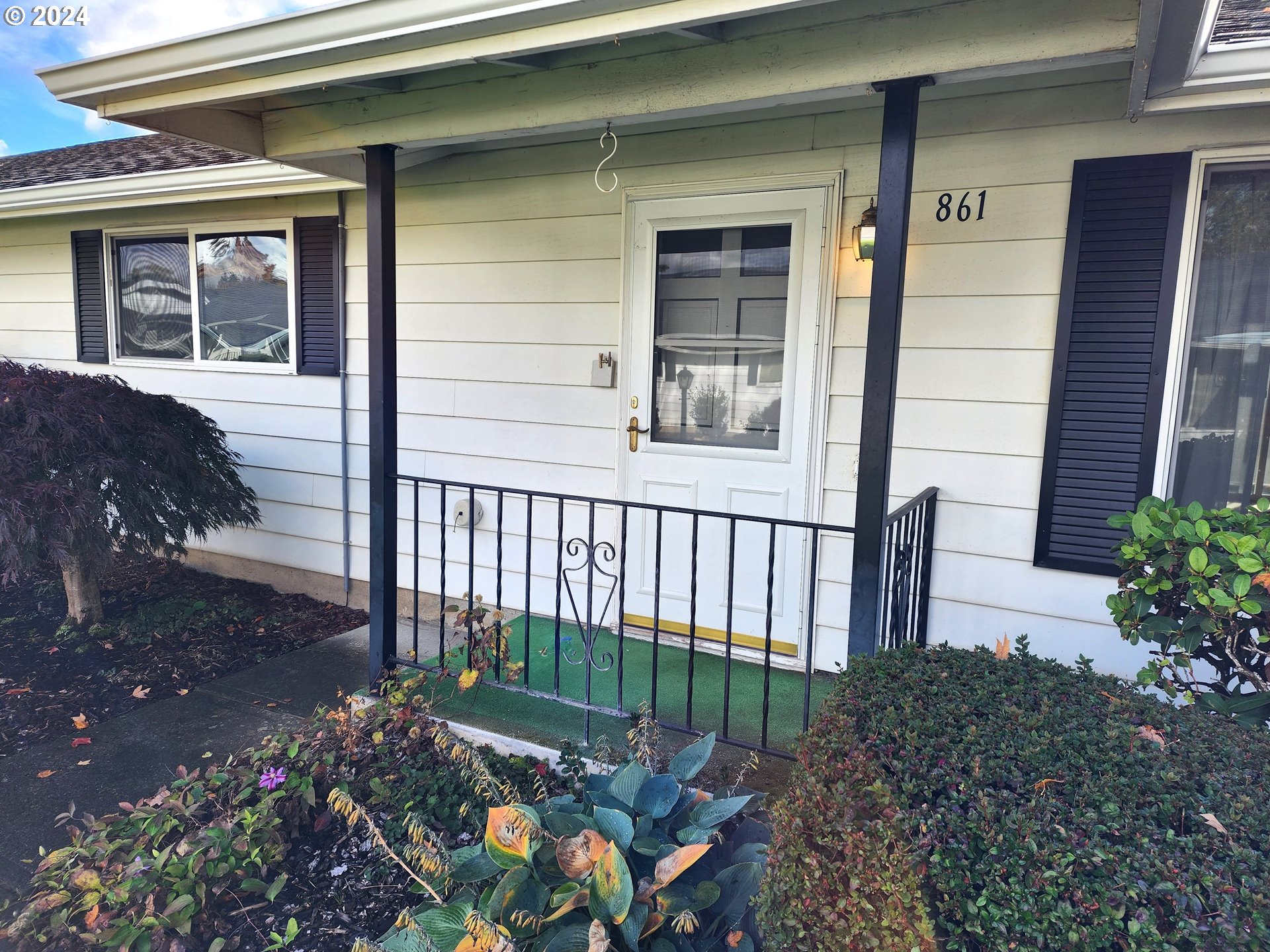 a view of a house with a small yard and flower plants