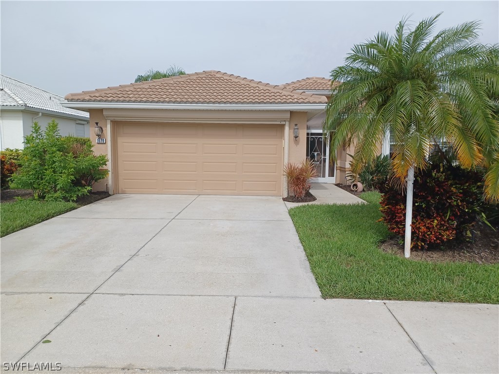 front view of house with a yard and palm trees