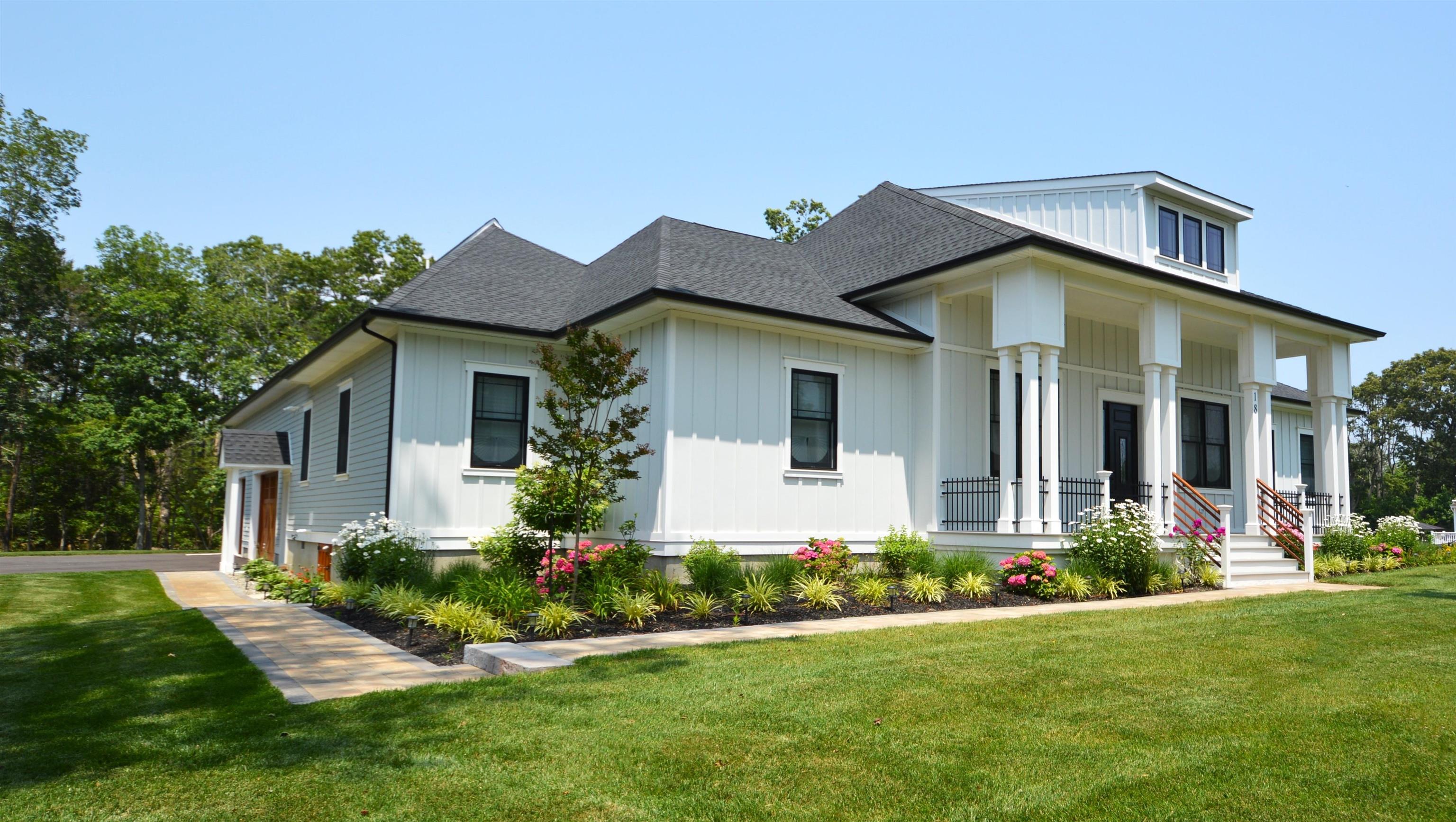 a front view of a house with a yard and potted plants