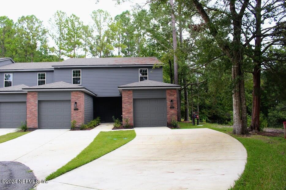 a front view of a house with a garden and trees