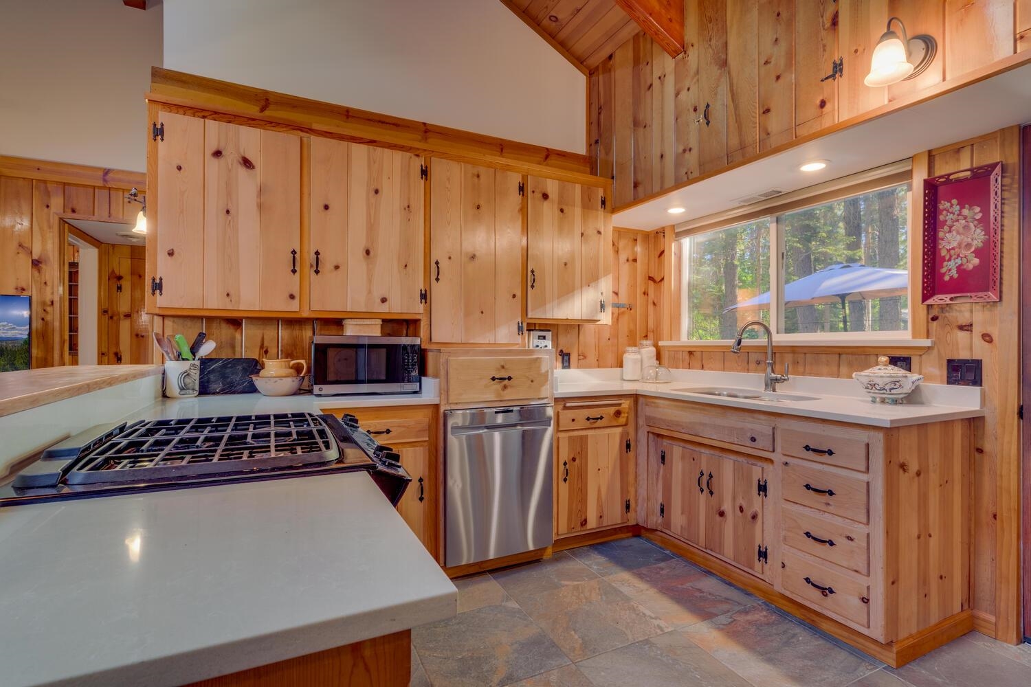 a kitchen with stainless steel appliances granite countertop a stove a sink dishwasher and cabinets with wooden floor