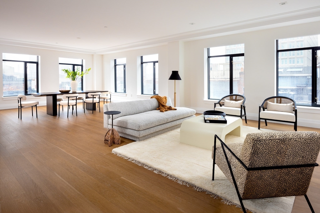 a living room with furniture and floor to ceiling windows