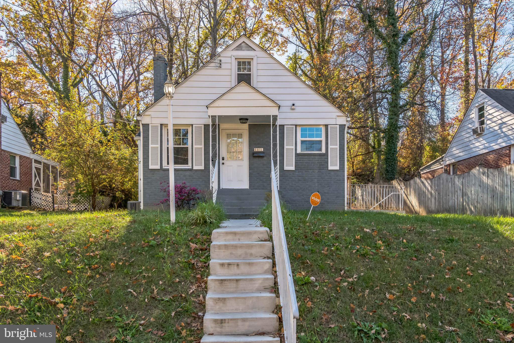 a front view of a house with a yard and trees