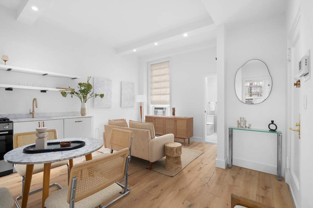 a living room with furniture a window and wooden floor