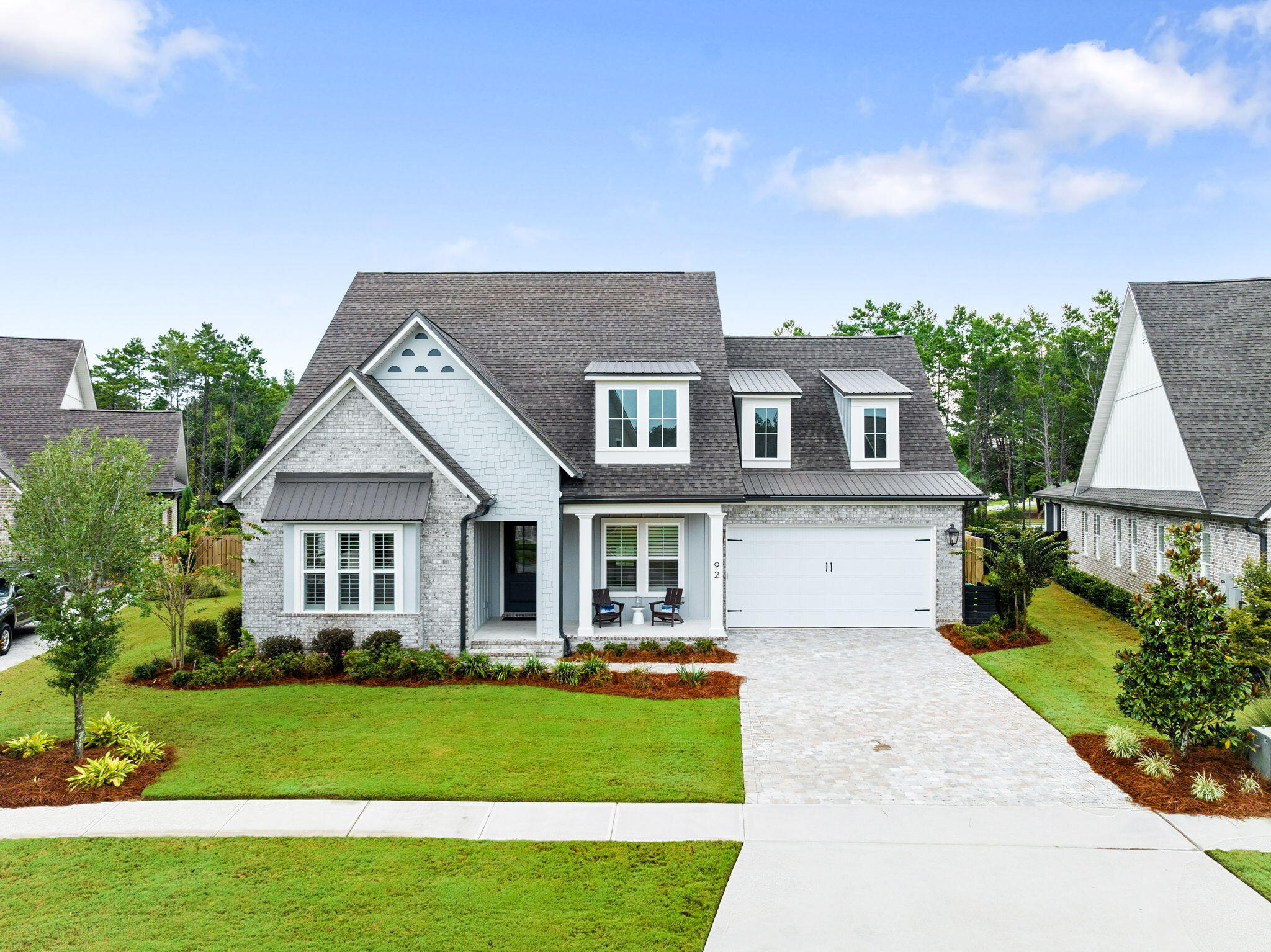 a front view of a house with a yard and potted plants