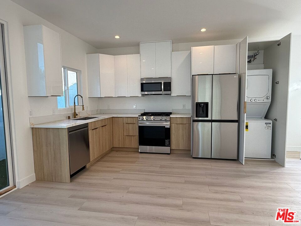 a kitchen with wooden cabinets stainless steel appliances and a window