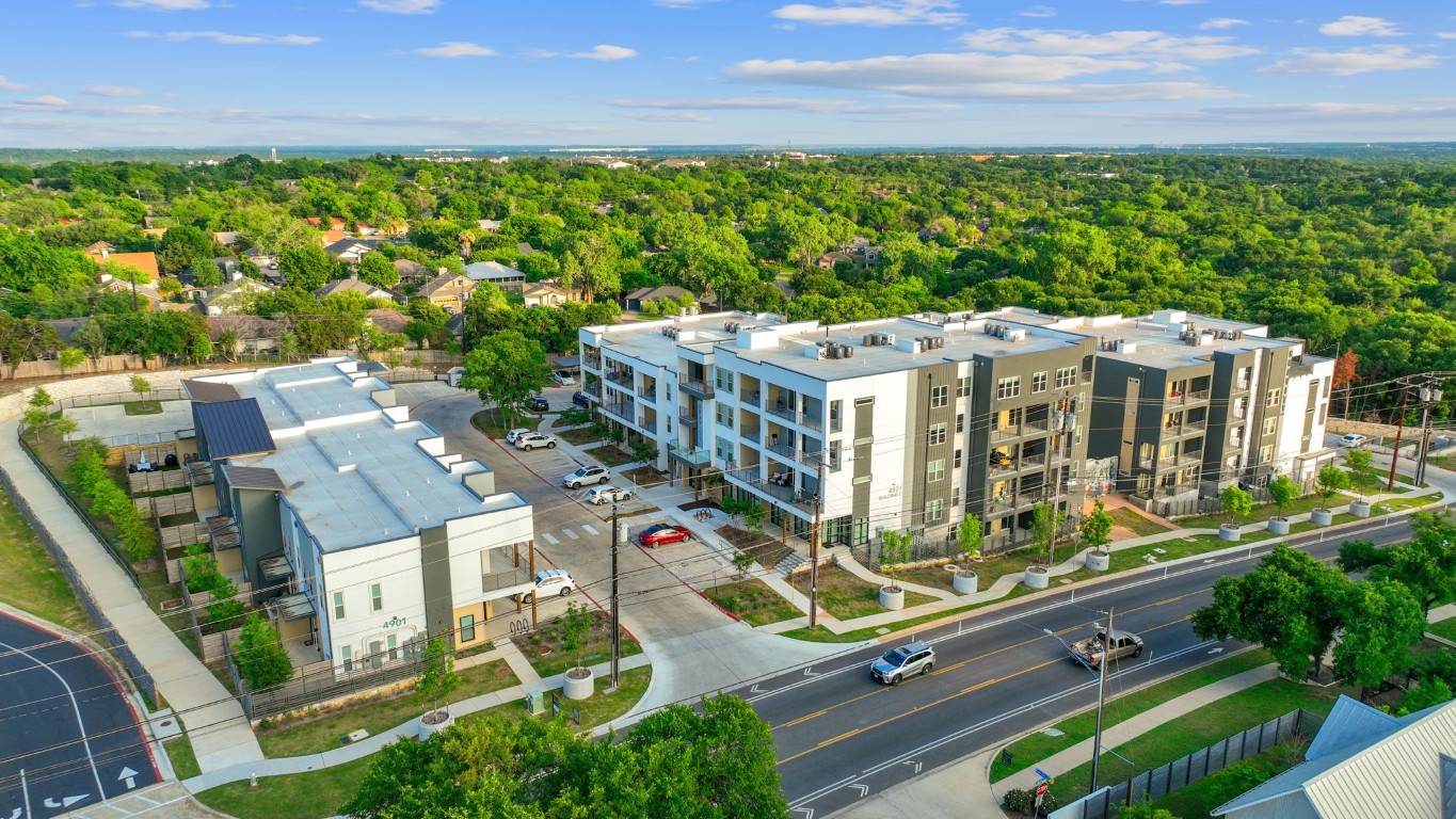 an aerial view of multiple houses with a yard