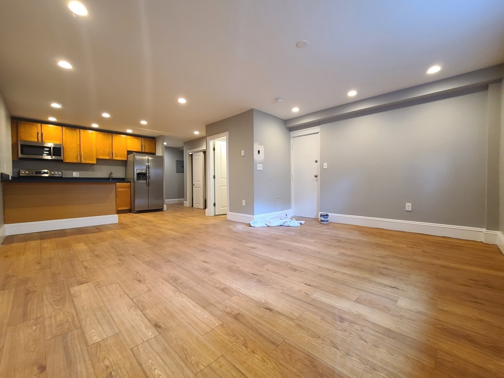 a view of empty room with wooden floor