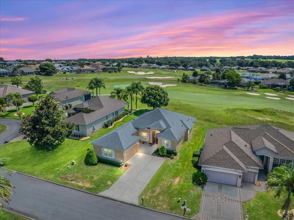 an aerial view of a house with a garden and a lake view