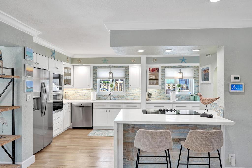 a kitchen with stainless steel appliances kitchen island granite countertop a kitchen island and chairs in it