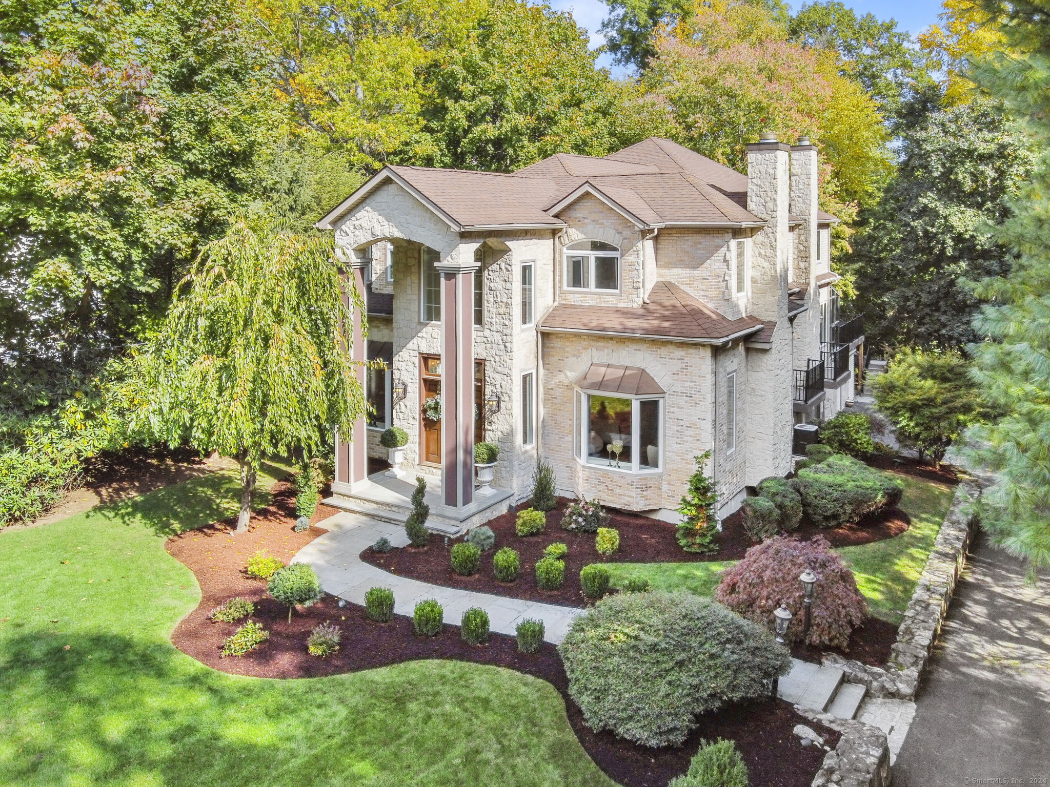 a view of a white house with a big yard and large tree