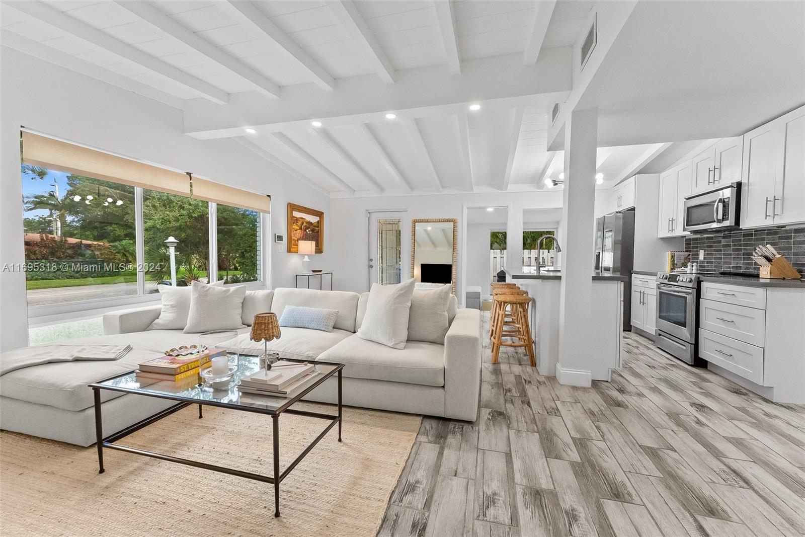 a living room with furniture wooden floor and a large window