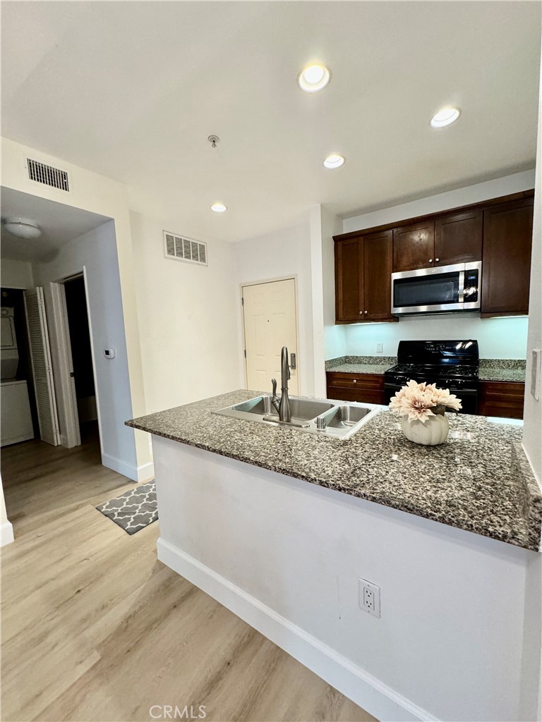 a kitchen with stainless steel appliances granite countertop a sink and a stove