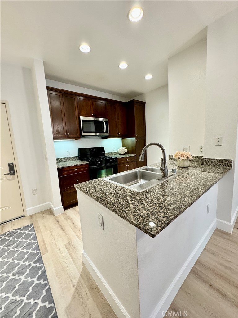 Kitchen with brand new microwave and refrigerator. Brand new flooring throughout the entire home.