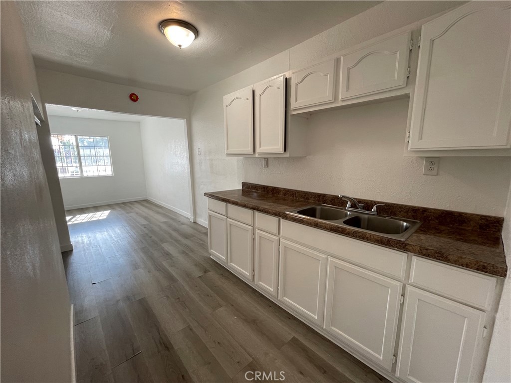 a kitchen with granite countertop a sink a stove and cabinets