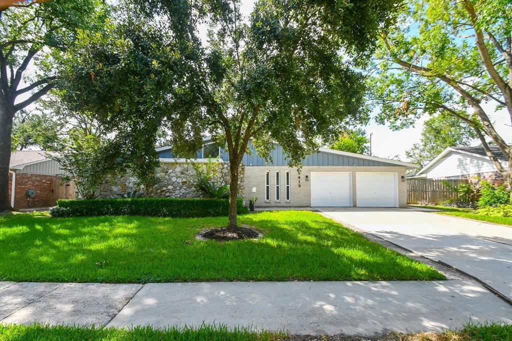 a front view of a house with a yard and tree