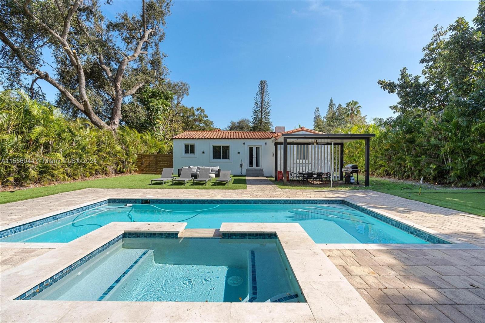 a view of swimming pool with lounge chair and trees in the background