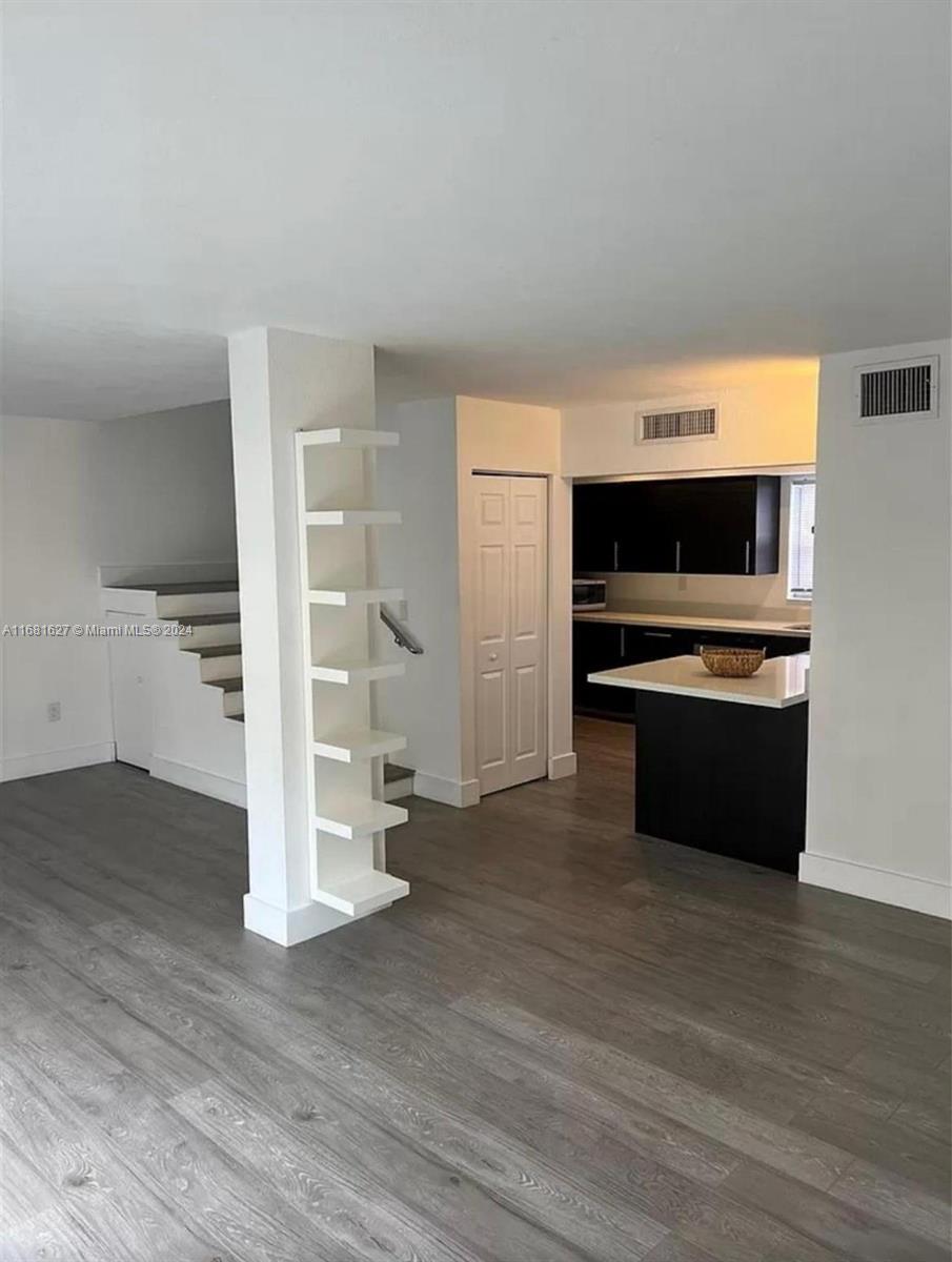 a view of a room with wooden floor and electronic appliances