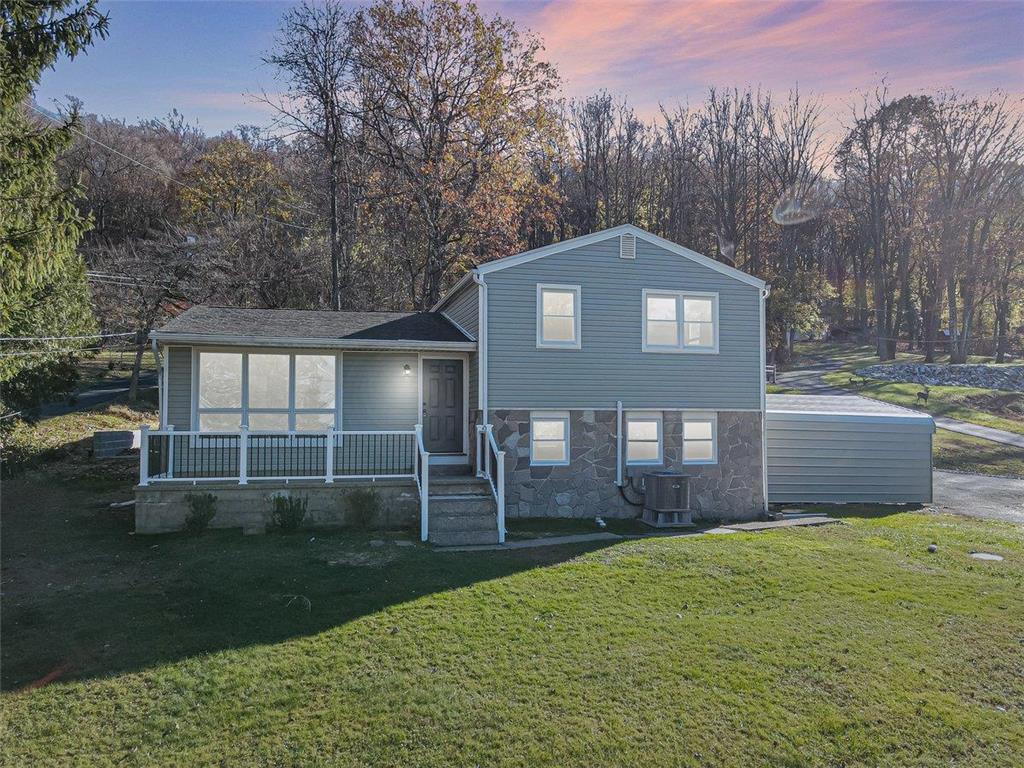 a front view of a house with a yard and trees