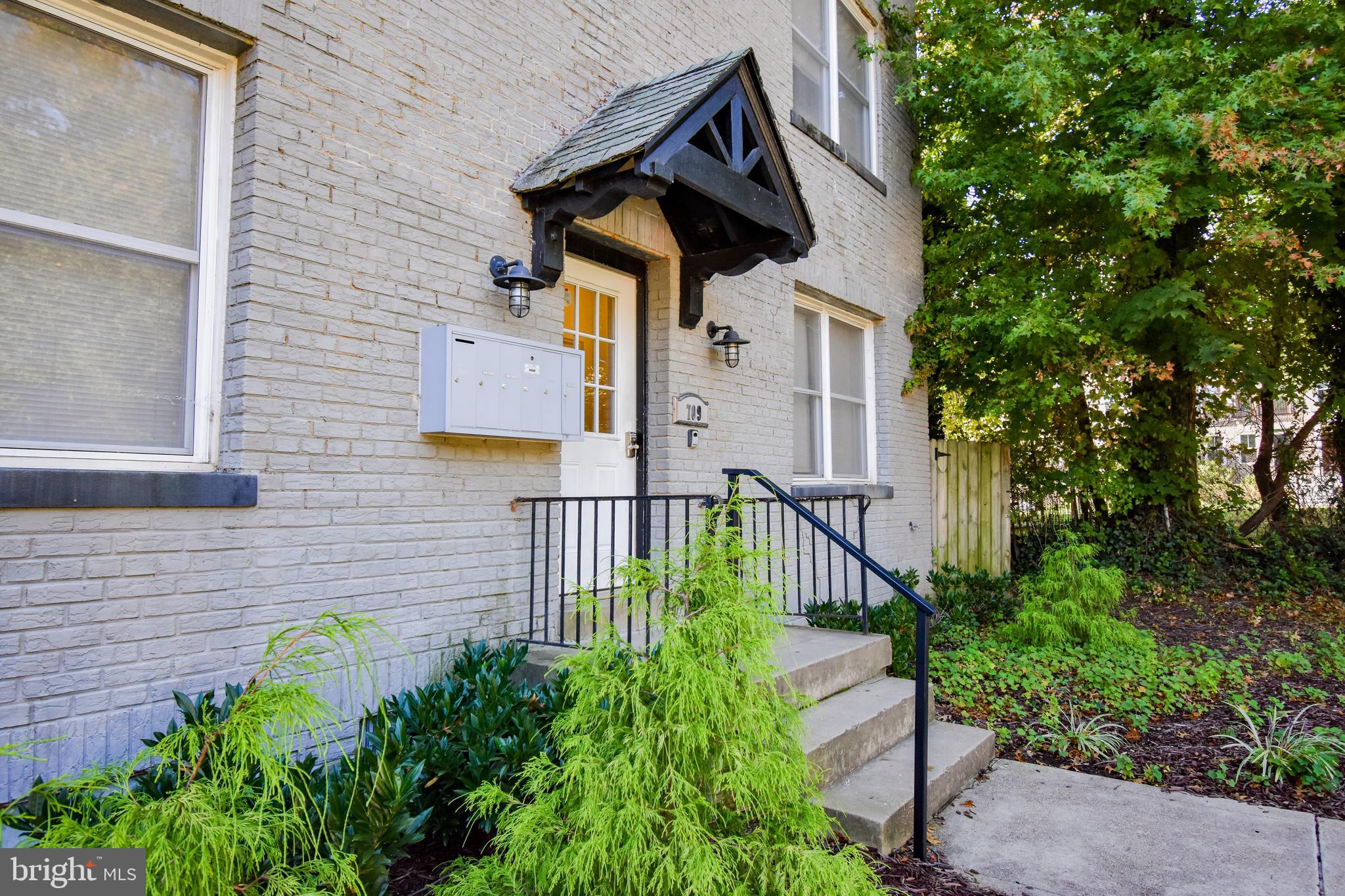 a view of a brick house with a flower garden