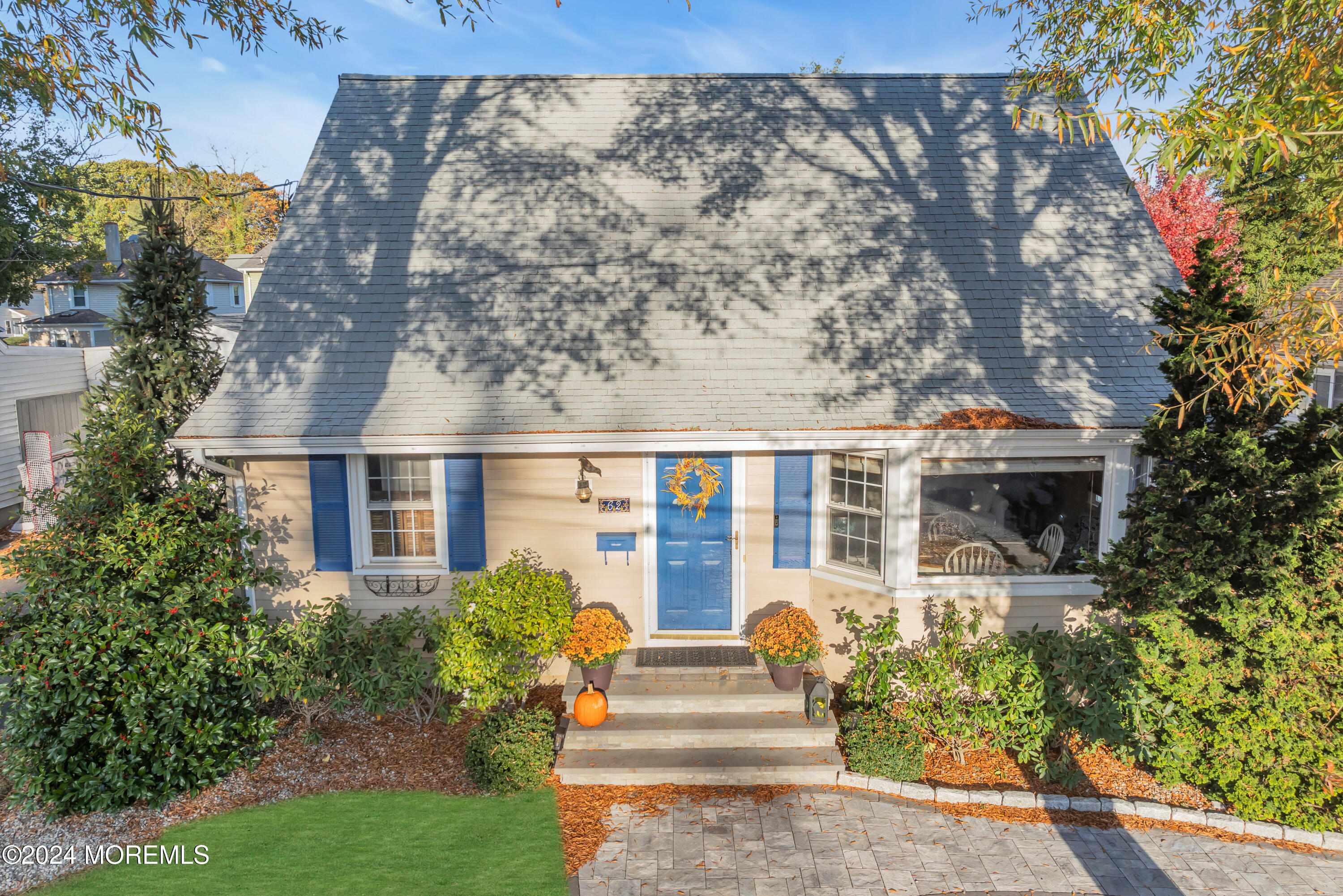 front view of house with a yard and potted plants