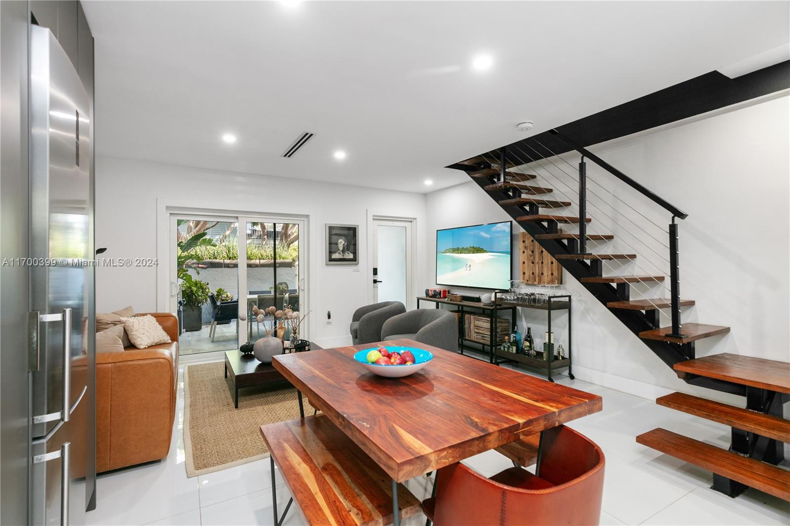 a living room with furniture a wooden floor and a large window