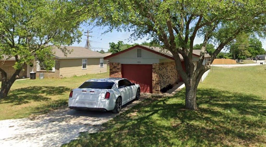 a car parked in front of a house with a small yard