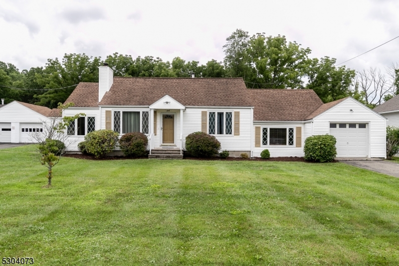 a front view of a house with a yard and trees