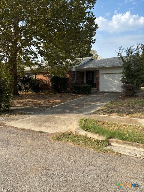 a view of a house with a yard and large tree