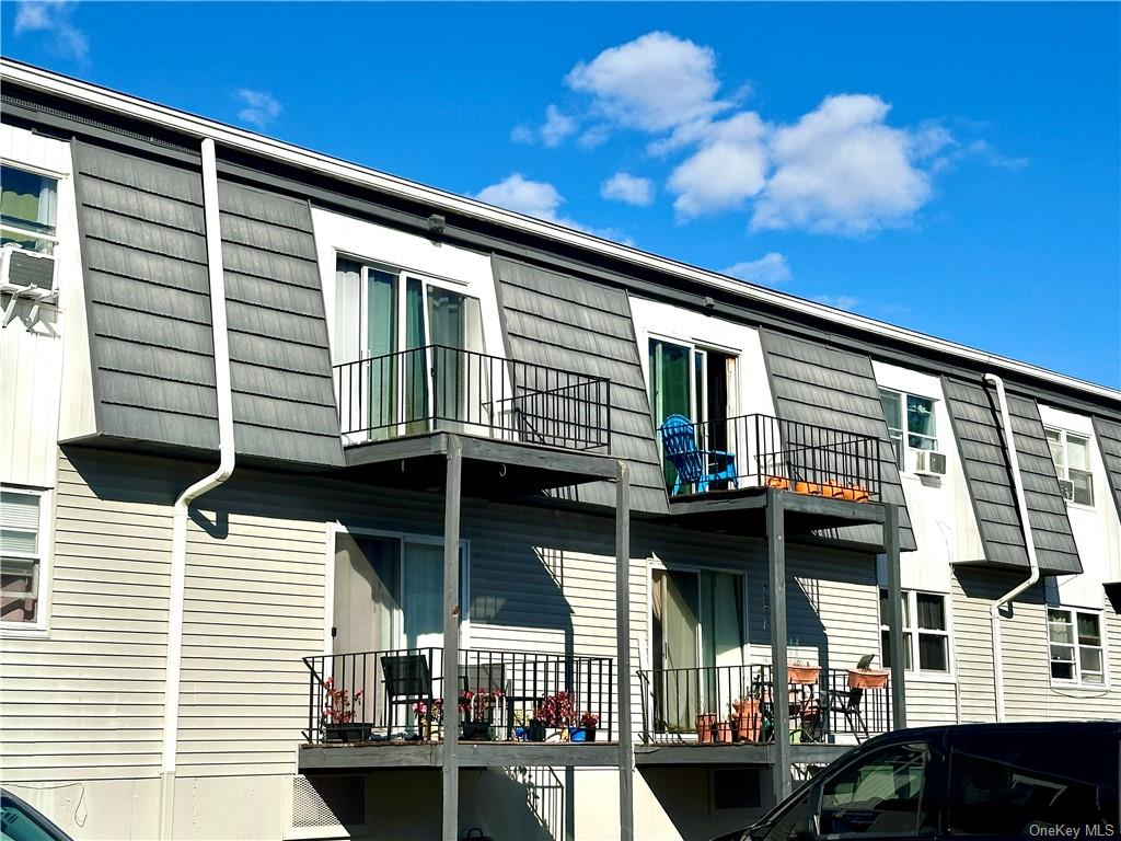 View of property exterior featuring cooling unit and a balcony