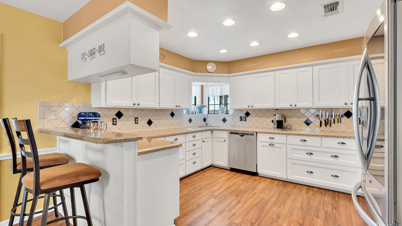 a kitchen with granite countertop white cabinets and white appliances