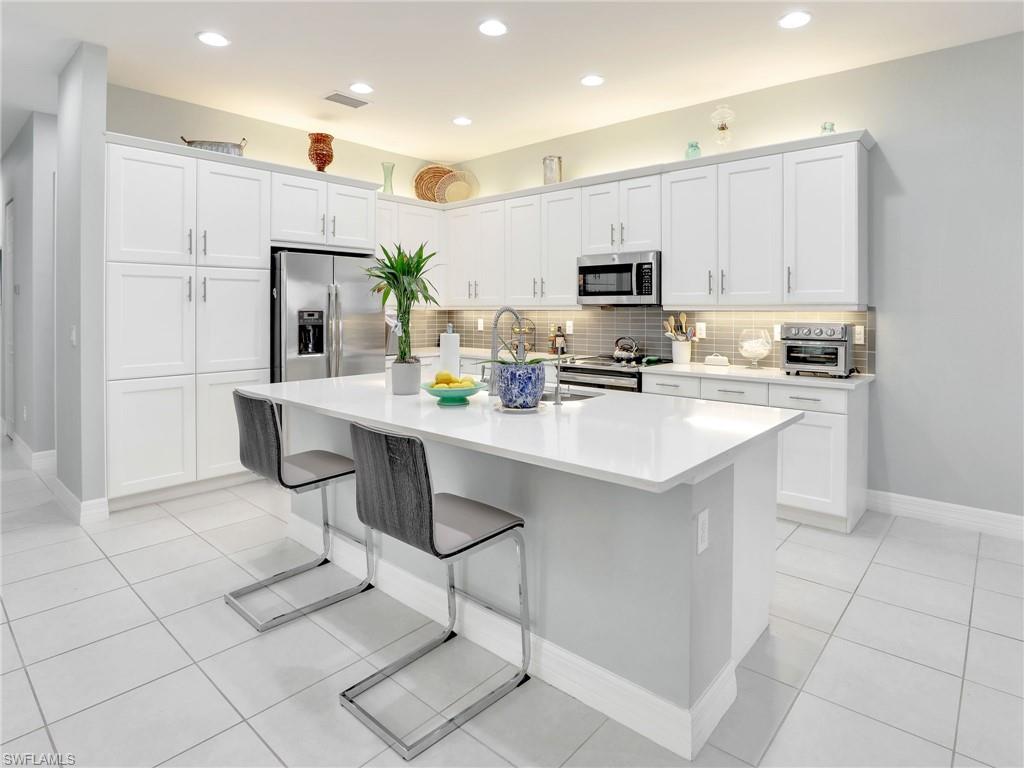 a kitchen with stainless steel appliances a sink a stove a refrigerator cabinets and a counter top space