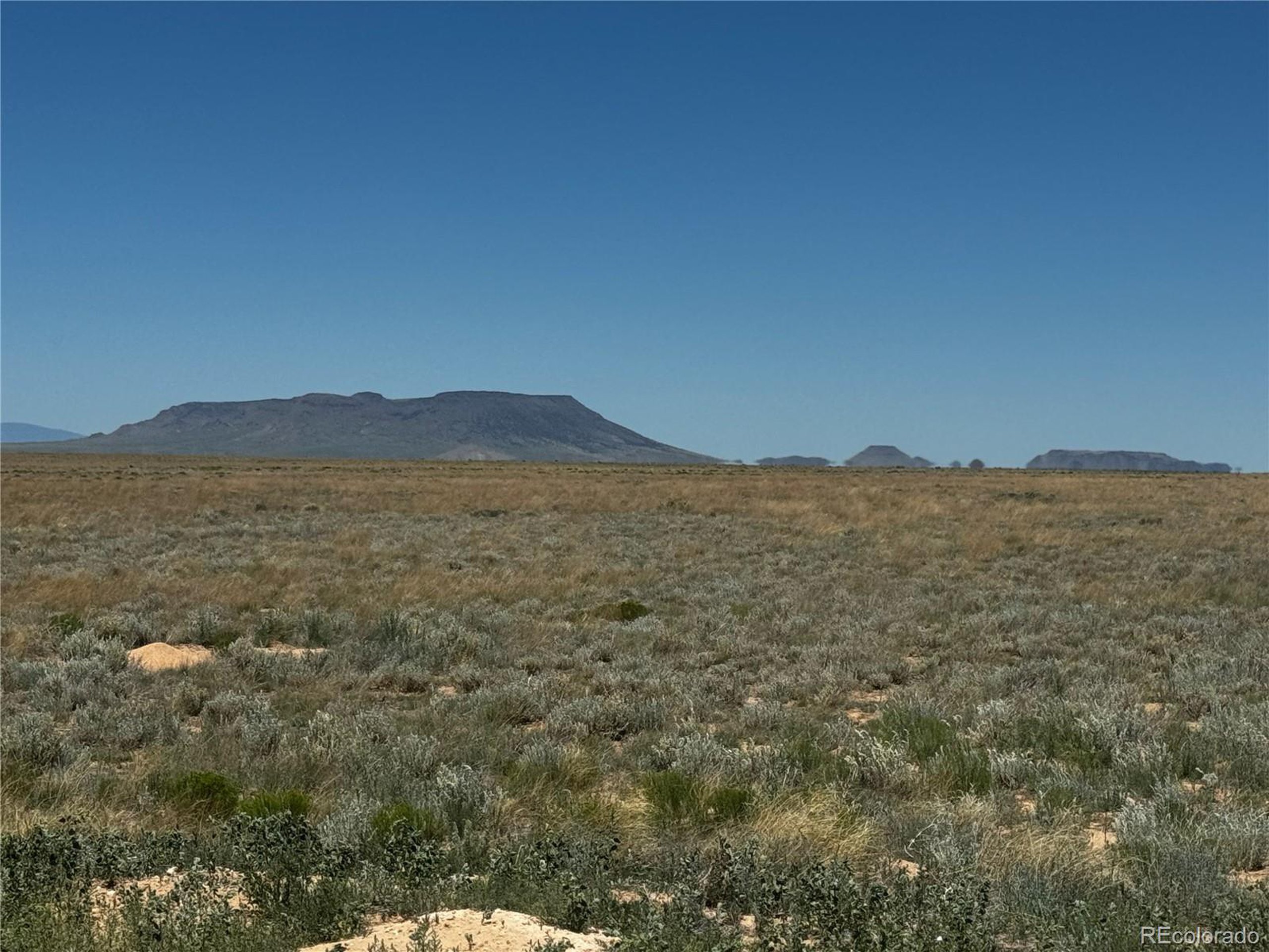 a view of a large mountain with mountains in the background