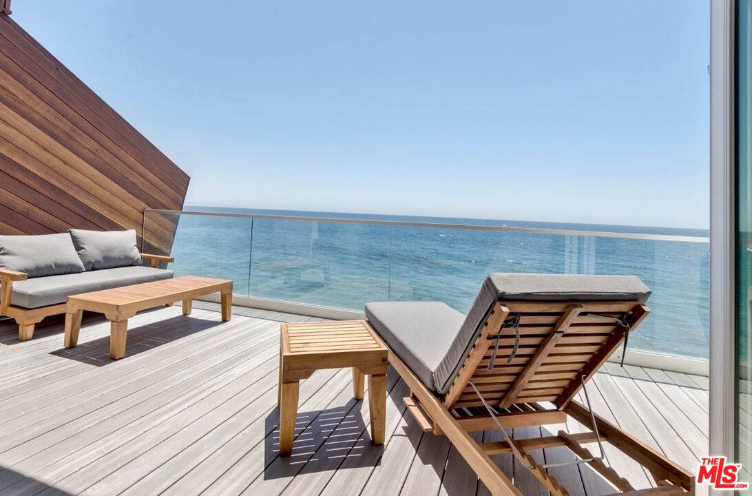 a roof deck with a couple of chairs