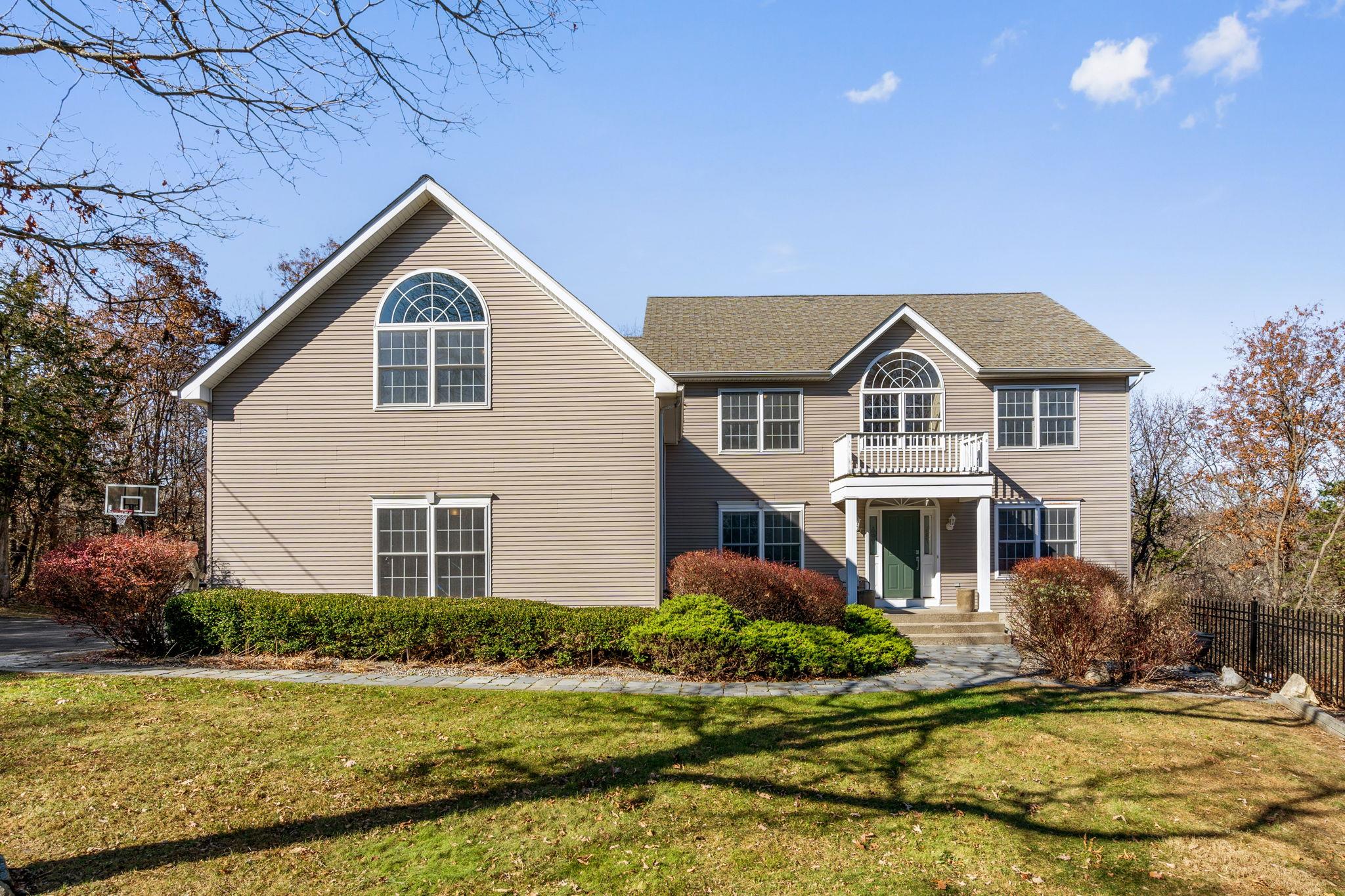 View of front of house with a front yard and a balcony