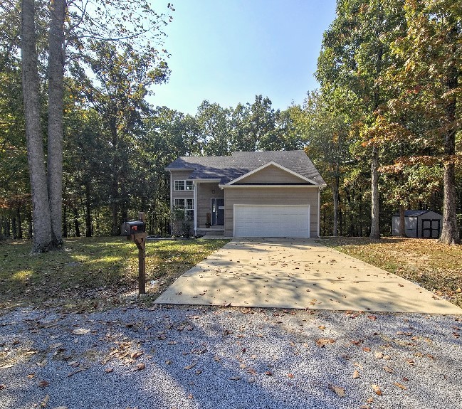 a front view of a house with a yard garage and tree