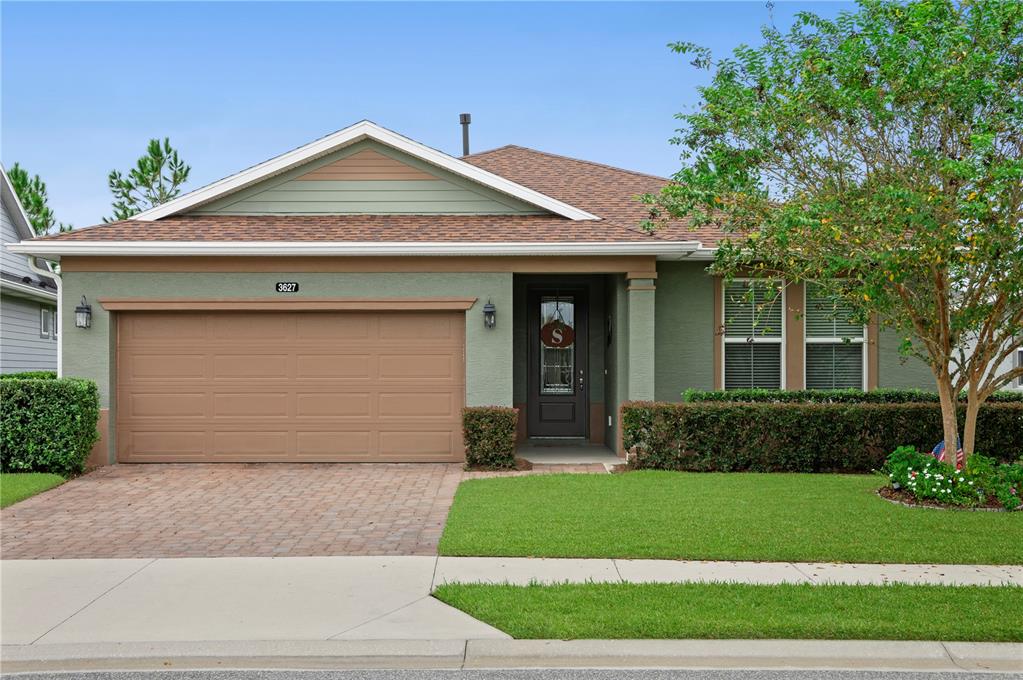 a front view of a house with a garden and yard