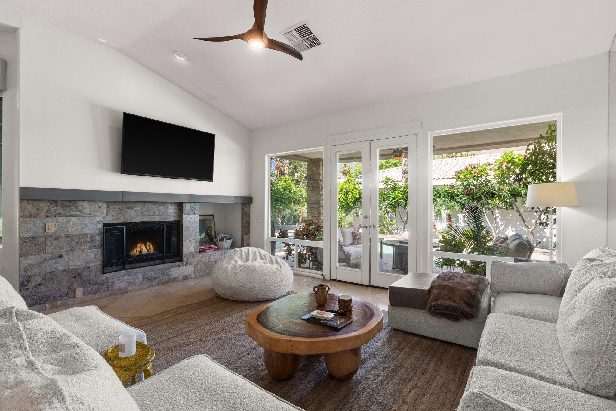 a living room with furniture a fireplace and a large window