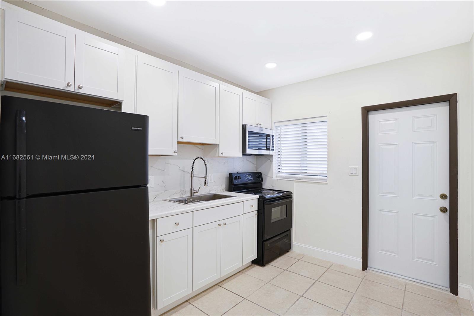 a kitchen with a refrigerator and a stove top oven