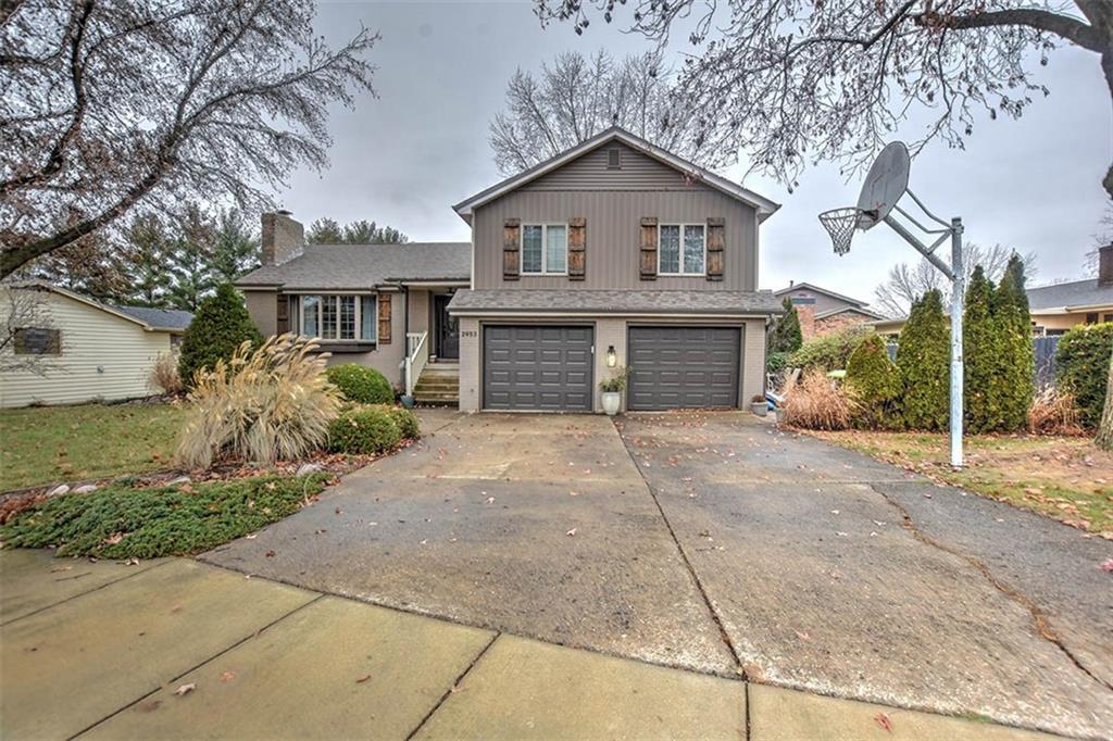 front view of a house with a yard and a garage