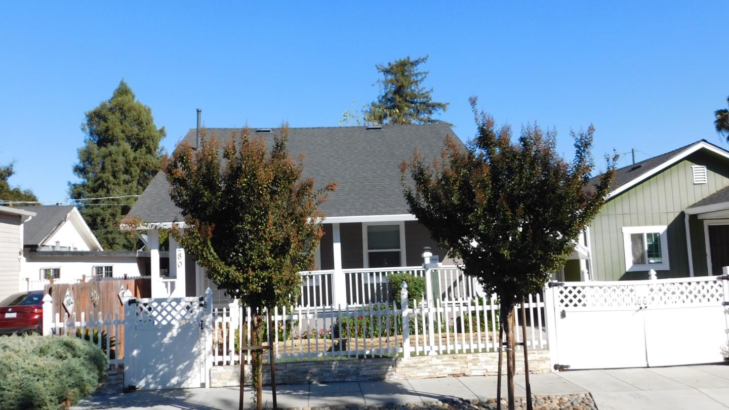 a front view of a house with a tree