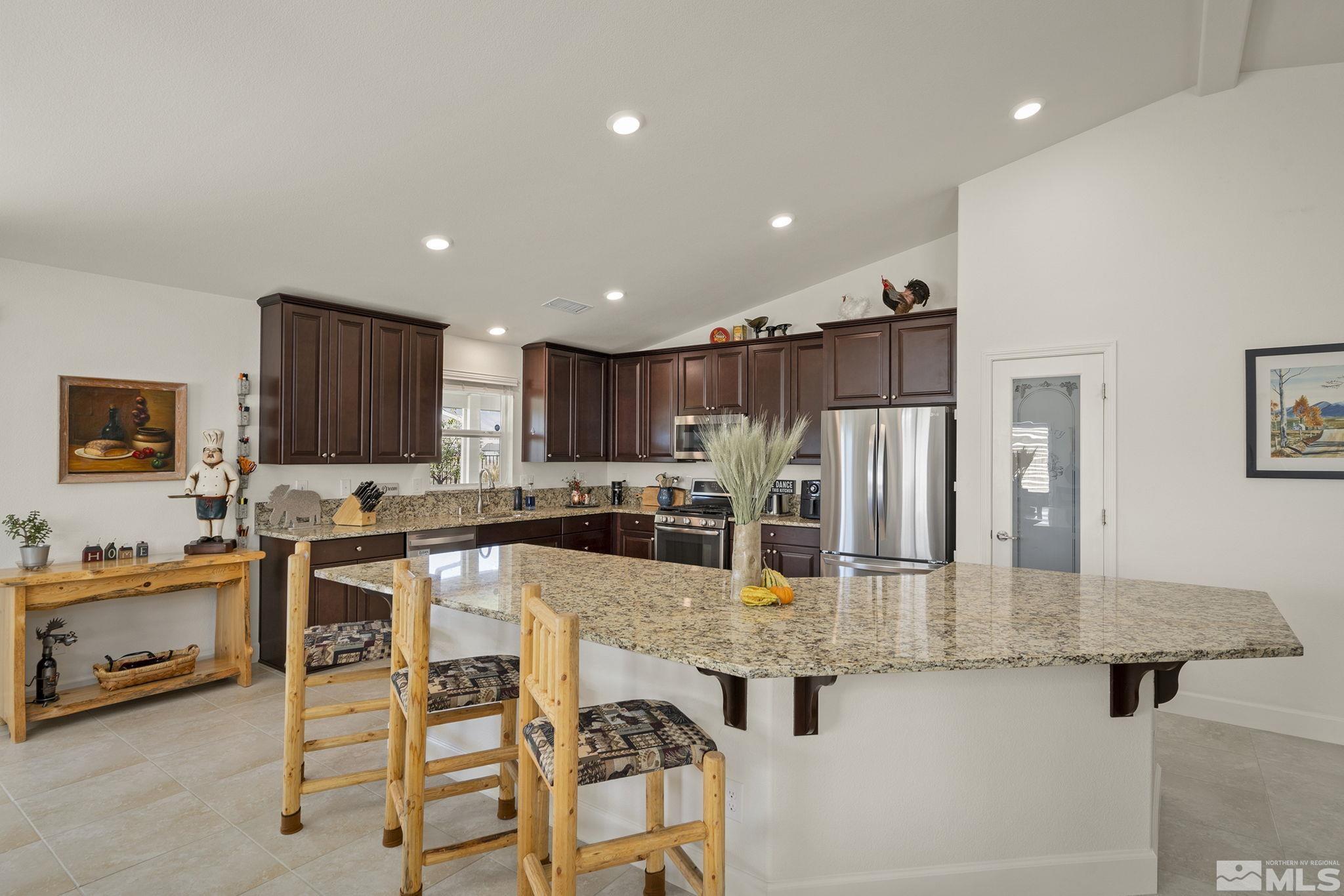 a kitchen with stainless steel appliances kitchen island granite countertop a sink and cabinets