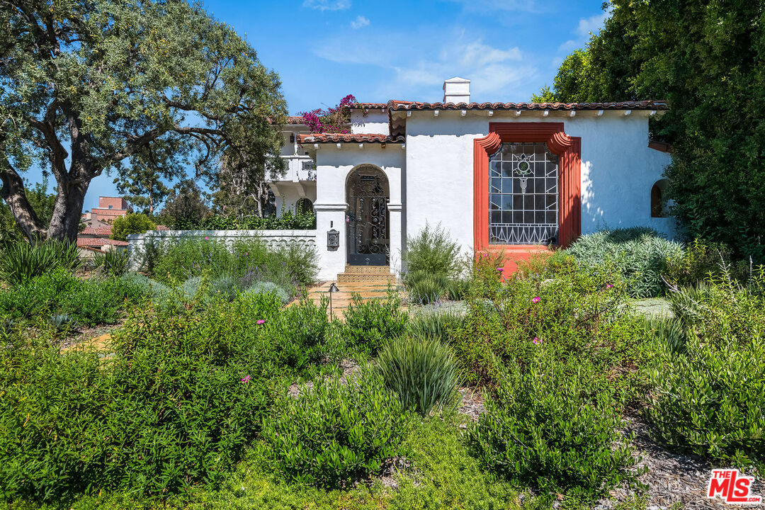 an aerial view of a house with garden space and trees all around