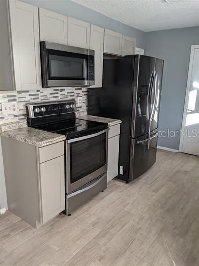 a kitchen with a refrigerator stove and microwave