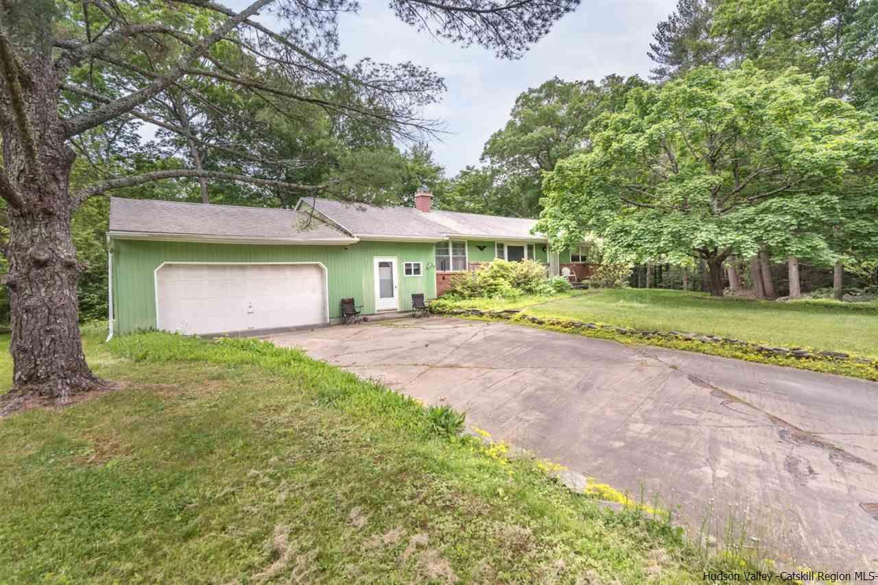 a front view of a house with a yard and trees