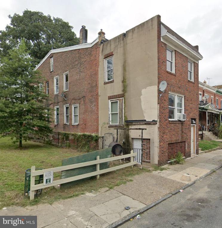 a view of a brick house with many windows next to a yard